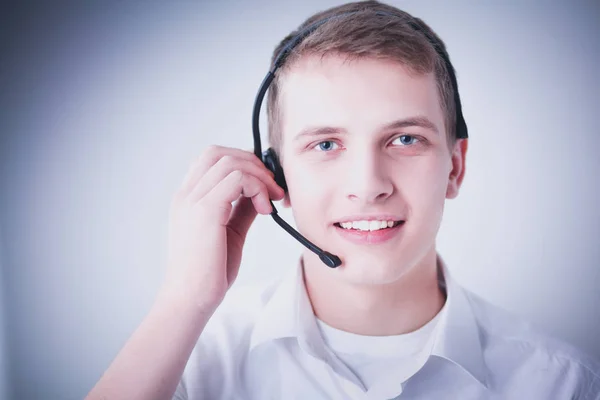 Retrato de un joven sonriendo sentado sobre un fondo gris. Retrato del joven — Foto de Stock