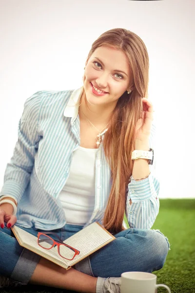 Jonge vrouw zit met boek op gras. Jonge vrouw — Stockfoto