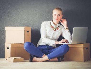 Dizüstü bilgisayar ile bir kutu yakınındaki katta oturan Bayan. İş kadını