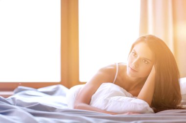 Evdeki yatakta uzanmış güzel esmer