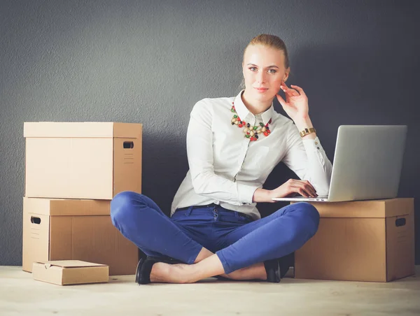 Mujer sentada en el suelo cerca de una caja con portátil. Empresaria —  Fotos de Stock