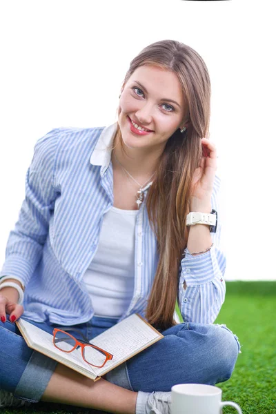 Jonge vrouw zit met boek op gras. Jonge vrouw — Stockfoto