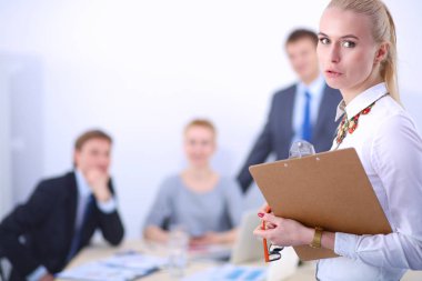 Ofiste çalışan genç bir kadının portresi klasörle duruyor. Genç bir kadının portresi. İş kadını