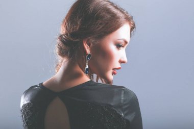 Siyah elbiseli, akşam makyajlı güzel bir kadın.