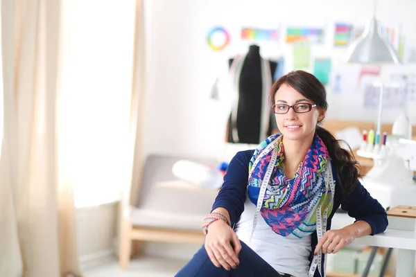 Beautiful fashion designer sitting at the desk in studio . — Stock Photo, Image