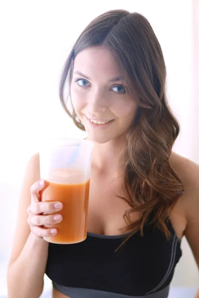 Portrait of a pretty woman holding glass with tasty juice. — Stock Photo, Image