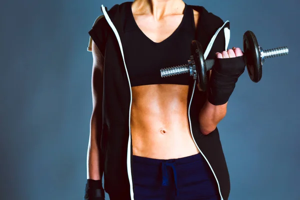 Young woman doing exercise with dumbbells isolated on dark background. — Stock Photo, Image