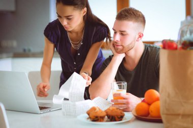 Çift evde mutfak içinde laptop ile onların fatura ödeme