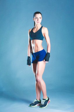 Spor giyim siyah arka plan karşı poz kas genç kadın