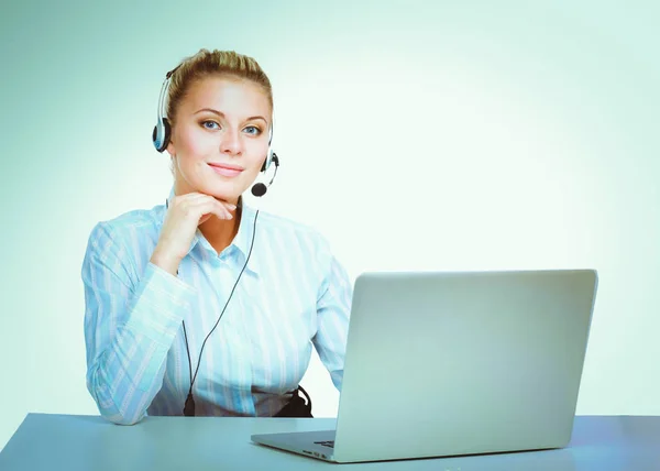 Retrato de mulher de negócios bonita trabalhando em sua mesa com fone de ouvido e laptop. — Fotografia de Stock