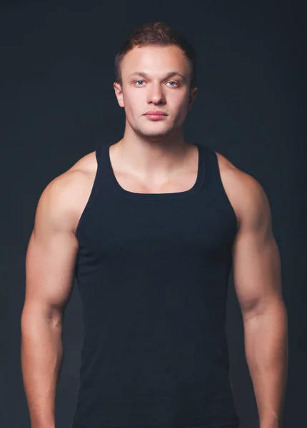 Zdrowe mięśni młody człowiek. na białym tle na czarnym tle — Zdjęcie stockowe