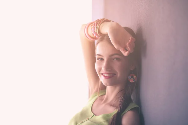 Mujer joven de pie cerca de la pared oscura — Foto de Stock