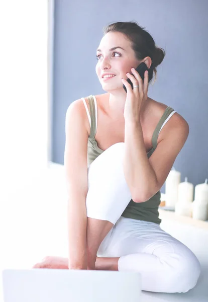 Aantrekkelijke Kaukasische meisje zittend op de vloer met telefoon — Stockfoto