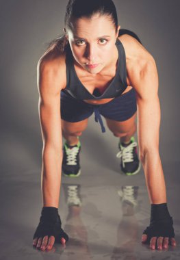 Paspasın üzerinde şınav çeken genç bir kadın..