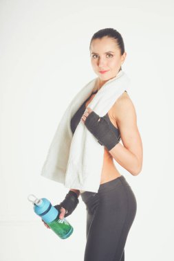 Beyaz arka plan üzerinde izole bir havlu ile duran genç güzel spor kadın.