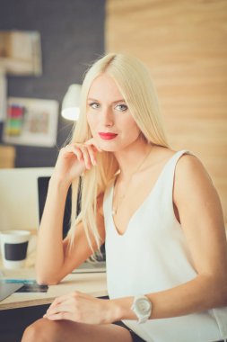 Moda tasarımcıları stüdyoda çalışıyor. Masanın üzerinde oturuyorlar..