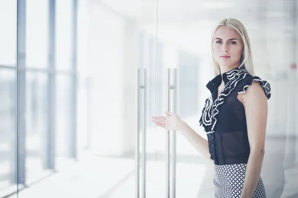 Een mooie blonde zakenvrouw opent de kantoordeur . — Stockfoto