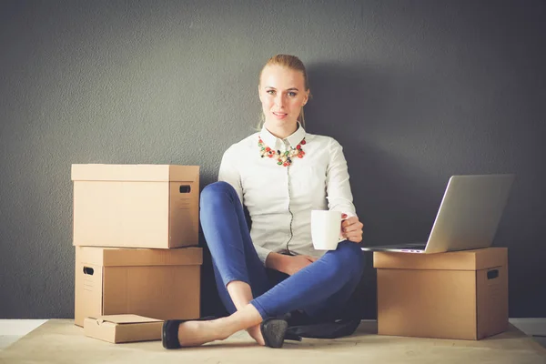 Femme assise sur le sol près d'une boîte avec ordinateur portable. Femme d'affaires — Photo