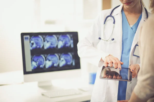 Doktorn och patienten diskuterar något när de sitter vid bordet. Medicin och hälsovård koncept. Läkare och patient — Stockfoto