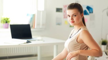 Masasında ve bilgisayarında evrakları olan bir kadın.