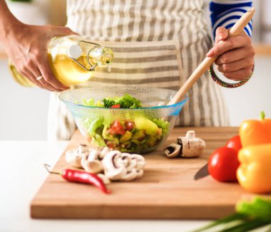 Genç kadın taze salata hazırlıyor.