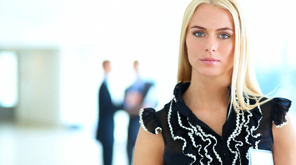 Business woman standing in foreground  in office