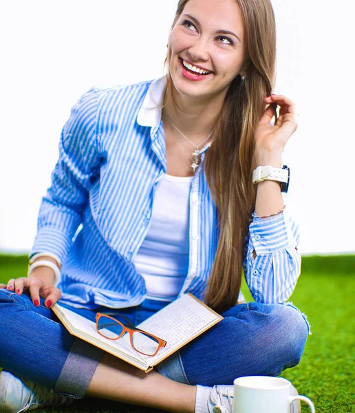 Jonge vrouw zitten met boek op gras — Stockfoto