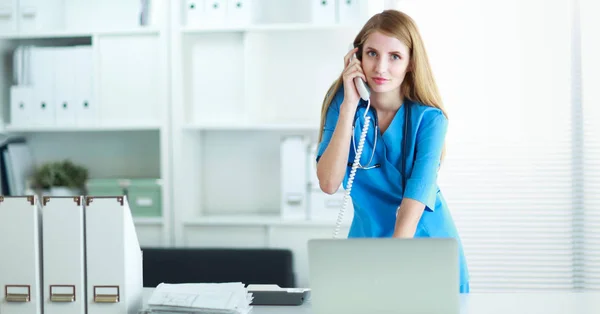 Vrouwelijke arts in gesprek over de telefoon in diagnostisch centrum — Stockfoto