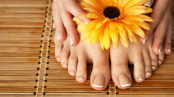 Уход за красивой женщиной ноги с цветами — стоковое фото