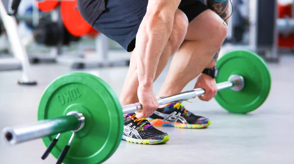 Culturista con barra de pesas en gimnasio — Foto de Stock