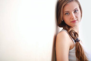 Duvarının yakınında katta oturan bir genç bayan. Genç kadın