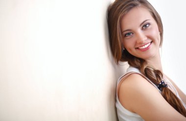 Duvarının yakınında katta oturan bir genç bayan. Genç kadın