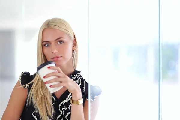 Geschäftsfrau mit einer Tasse Kaffee im Büro . — Stockfoto