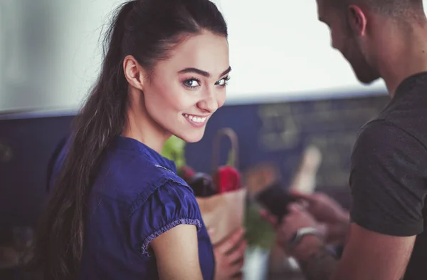 Lyckligt par använder smartphone stående i köket — Stockfoto