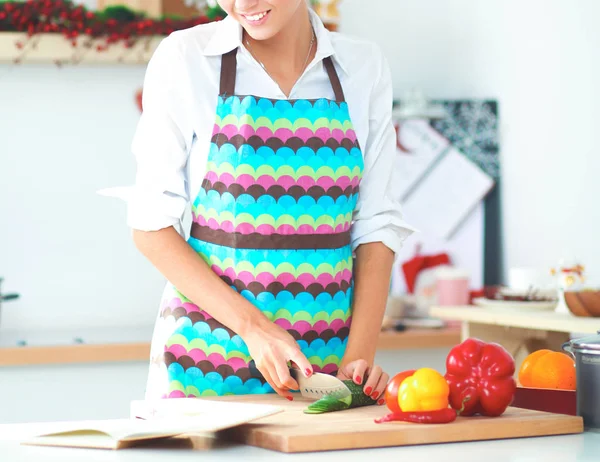 Jeune jolie femme coupant des légumes dans la cuisine — Photo