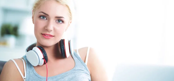 Young beautiful woman at home sitting on sofa and listening music — Stock Photo, Image