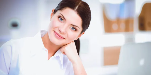 Attraktive Geschäftsfrau sitzt auf Schreibtisch im Büro — Stockfoto