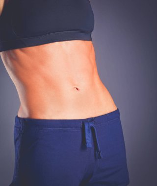 Spor giyim siyah arka plan karşı poz kas genç kadın