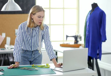 Stüdyoda çalışan genç moda tasarımcısı.