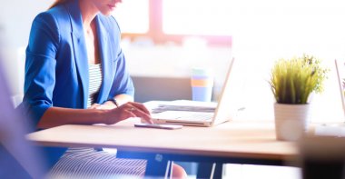 Masada dizüstü bilgisayarı olan kadın.