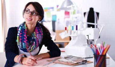 Terzi kadın kağıt üzerinde kıyafet deseni tasarlıyor.