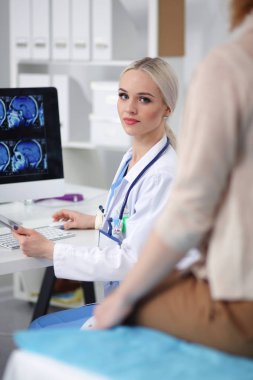 Doktor ve hasta masada otururken bir şey tartışıyorlar. Tıp ve sağlık hizmetleri kavramı. Doktor ve hasta.