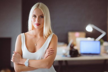 Moda tasarımcıları stüdyoda çalışıyor. Masanın üzerinde oturuyorlar..