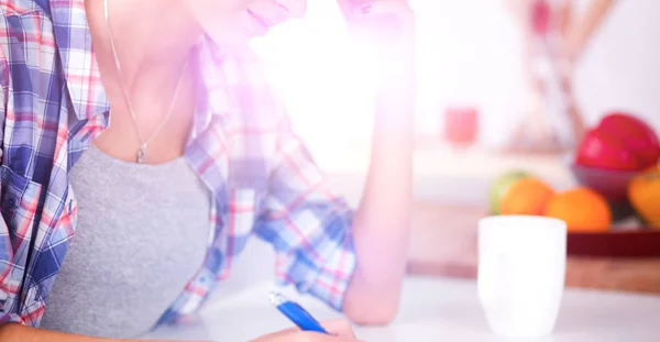 Junge Frau schreibt etwas in ihren Notizblock — Stockfoto