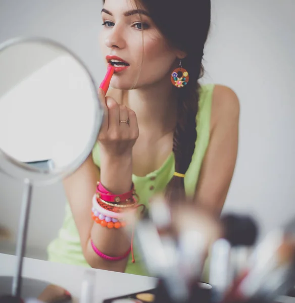 Joven hermosa mujer haciendo maquillaje cerca del espejo — Foto de Stock