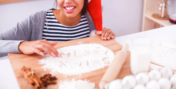 Happy young woman smiling happy having fun with Christmas preparations wearing Santa hat — Stock Photo, Image