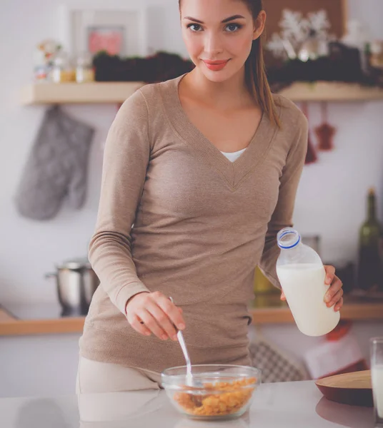 Улыбающаяся привлекательная женщина завтракает в интерьере кухни — стоковое фото