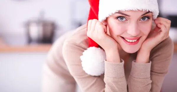 Sorridente giovane donna in cucina, isolata su sfondo natalizio — Foto Stock