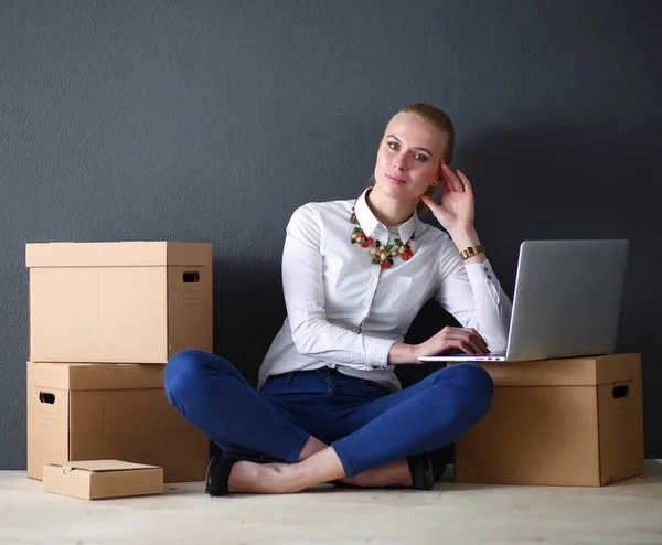 Mujer sentada en el suelo cerca de una caja con portátil. Empresaria —  Fotos de Stock