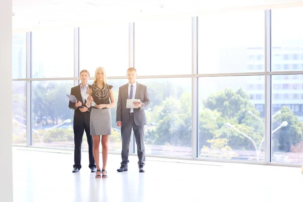 Zakenvrouw permanent op voorgrond in office . — Stockfoto